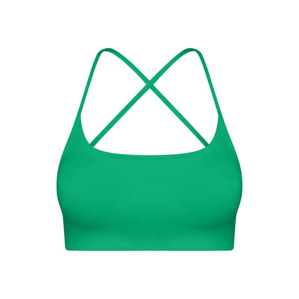 Emerald green seamless sports bra with crisscross strappy back for yoga and fitness.