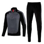 Black and grey men’s tracksuit set with quarter-zip pullover jacket and tapered pants.