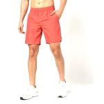 Man wearing coral red training shorts with side pockets and elastic waistband.