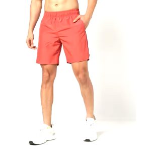 Man wearing coral red training shorts with side pockets and elastic waistband.