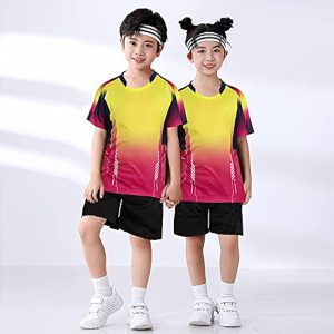Two kids in matching yellow and pink badminton outfits holding hands and smiling.
